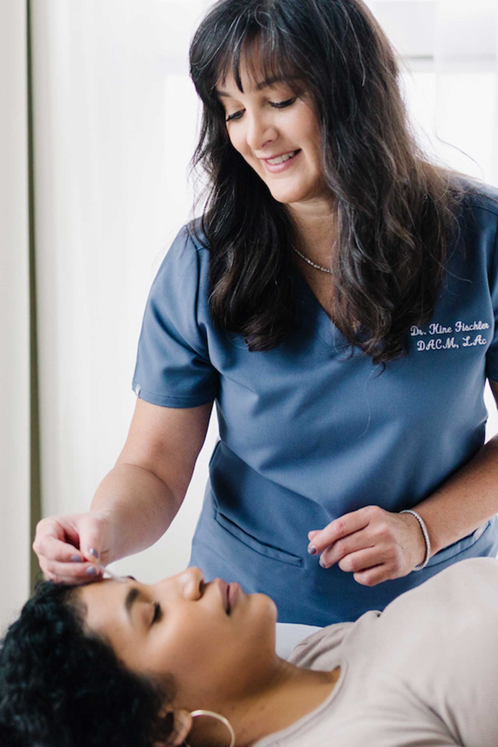 A healthcare professional performing an acupuncture treatment on a relaxed patient in Portland, Oregon.
