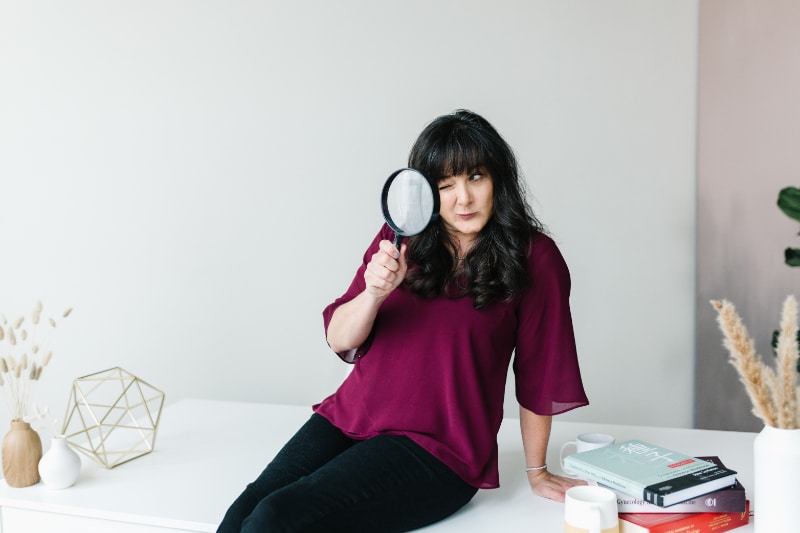 Dr. Kiné Fischler of Willow Tree Clinic in Portland holding up a microscope sitting on an acupuncture bed