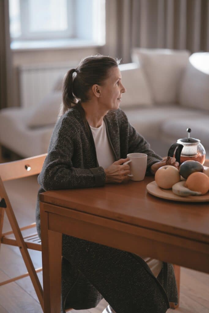 a woman sitting at a table with a mug
