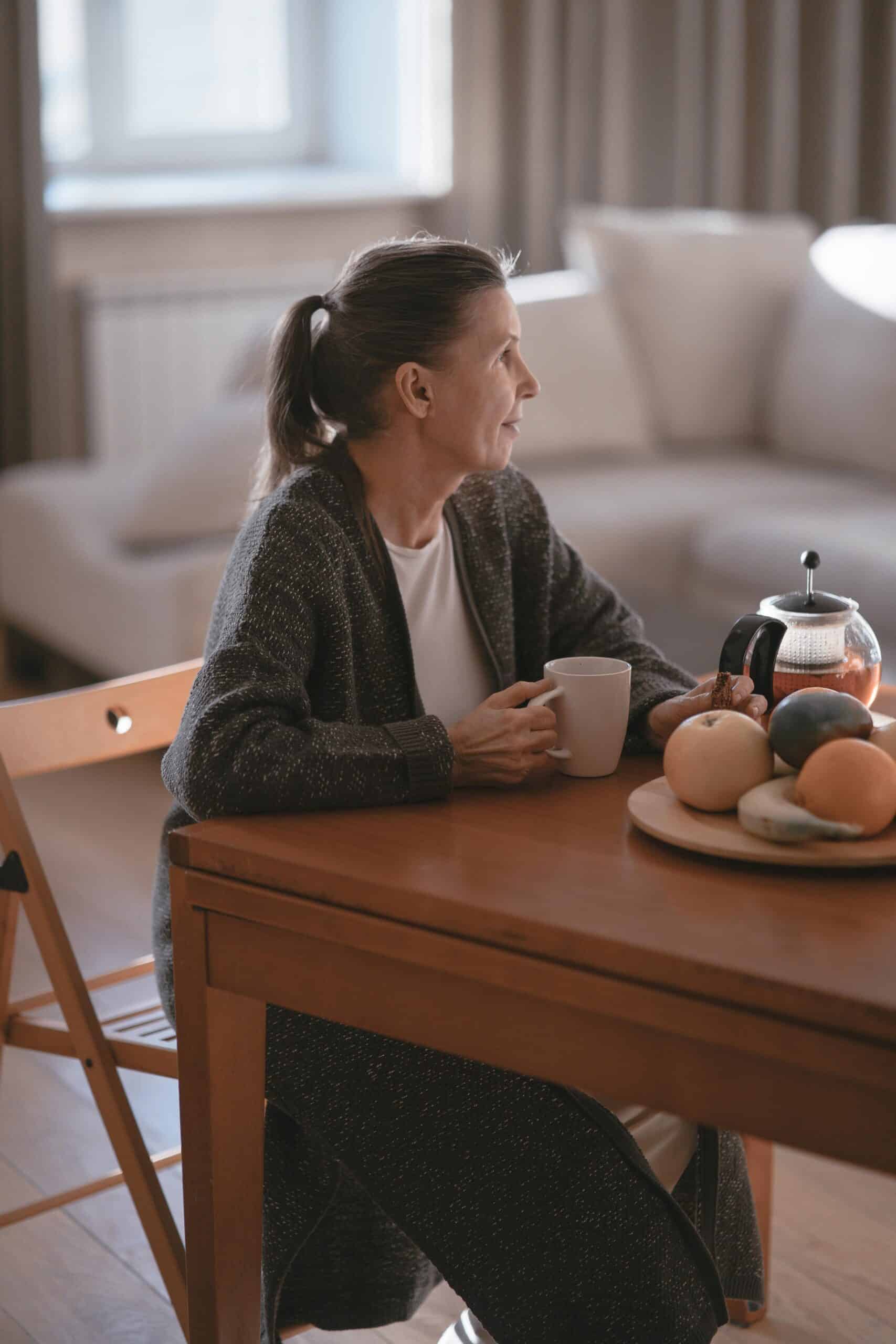 Woman thinking at the table about acupuncture for hot flashes