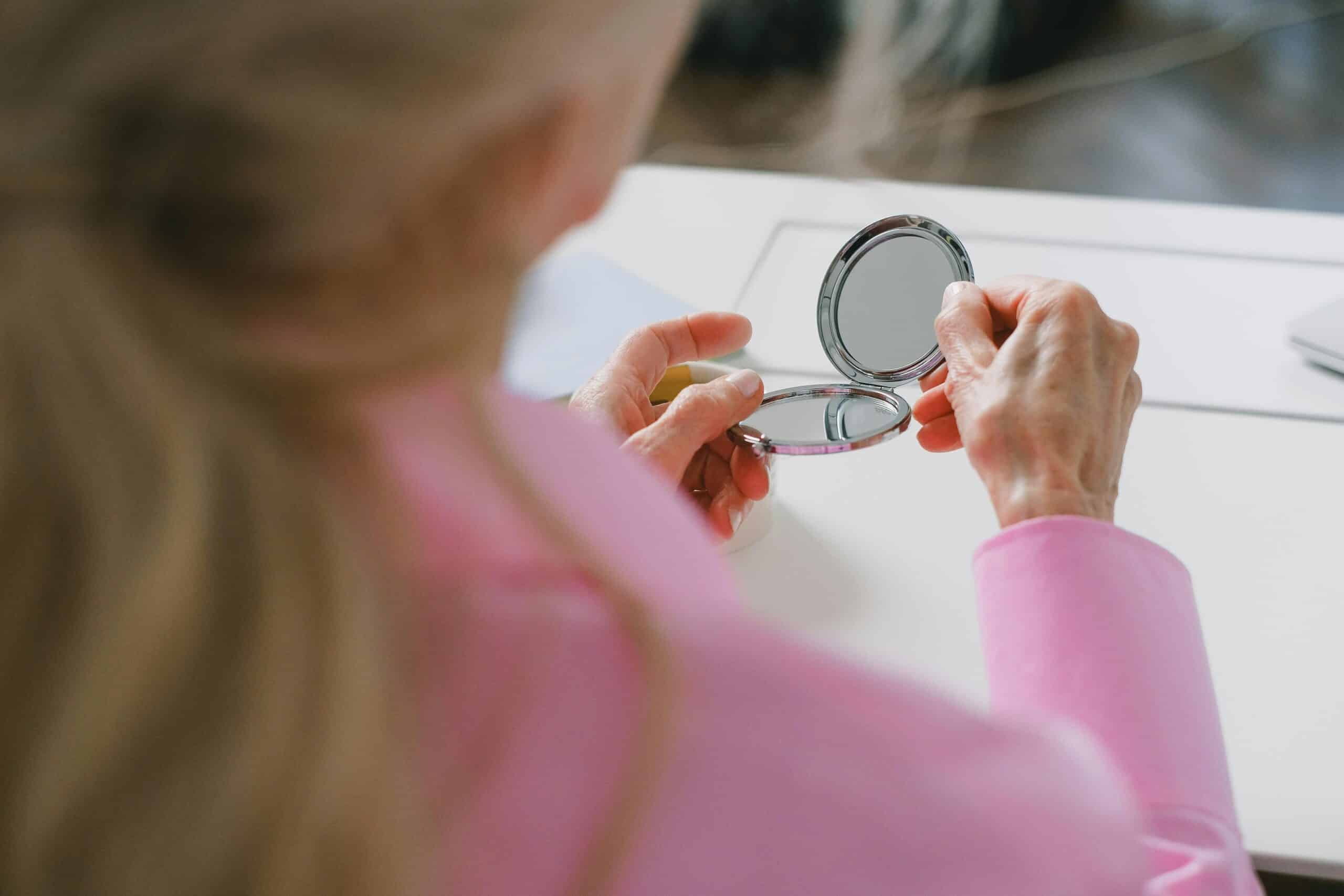 Woman looking in mirror during life after menopause