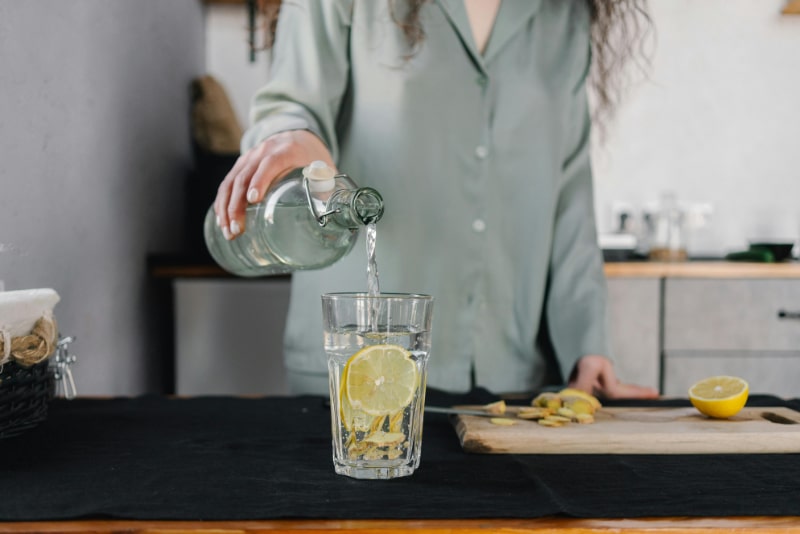 Morning wellness routine with lemon water, representing hydration, balance, and healthy habits supported by tune-up acupuncture.