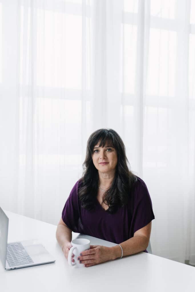 Dr. Kiné Fischler, DACM sits at desk as she talks about what causes sciatic nerve pain.