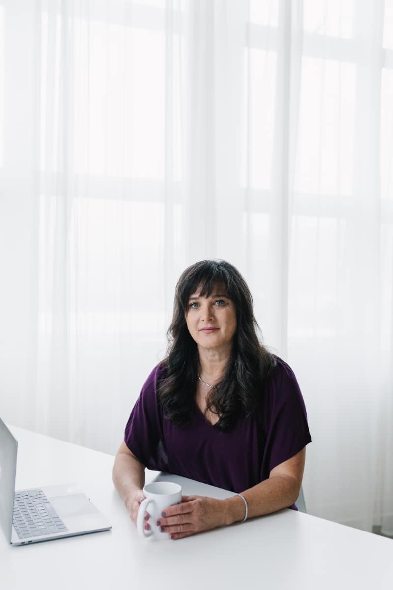 Dr. Kiné Fischler, DACM sits at desk as she talks about what causes sciatic nerve pain.